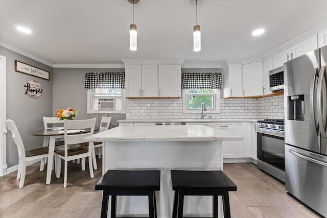 36 Porter Rd, Marlborough, MA 01752 - kitchen with appliances with stainless steel finishes, crown molding, backsplash, white cabinets, and a kitchen island