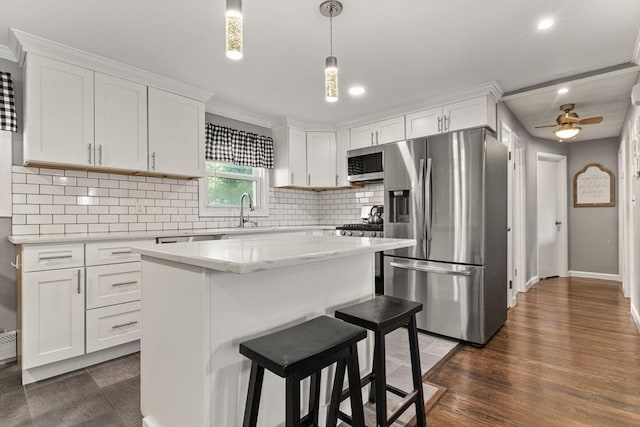 36 Porter Rd, Marlborough, MA 01752 - kitchen with appliances with stainless steel finishes, white cabinets, tasteful backsplash, a kitchen bar, and recessed lighting