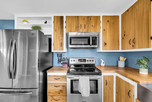 kitchen featuring open shelves, appliances with stainless steel finishes, and wooden counters