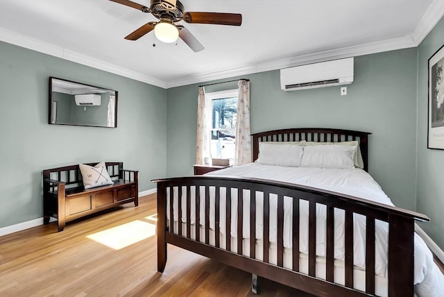 bedroom with ceiling fan, baseboards, a wall mounted air conditioner, ornamental molding, and wood finished floors