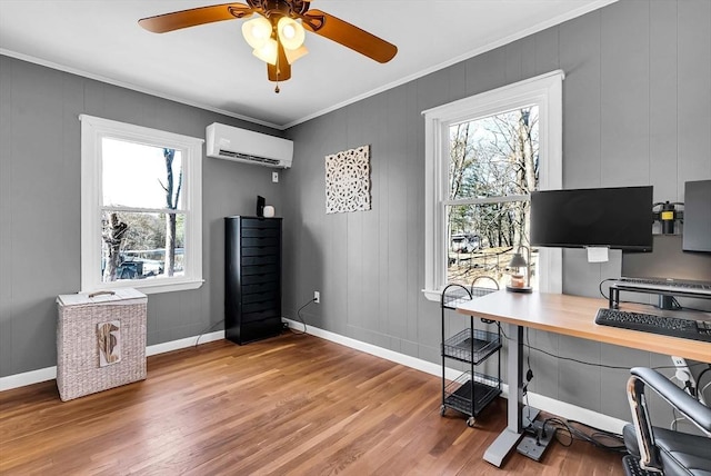 home office featuring a ceiling fan, baseboards, ornamental molding, a wall mounted air conditioner, and light wood-type flooring