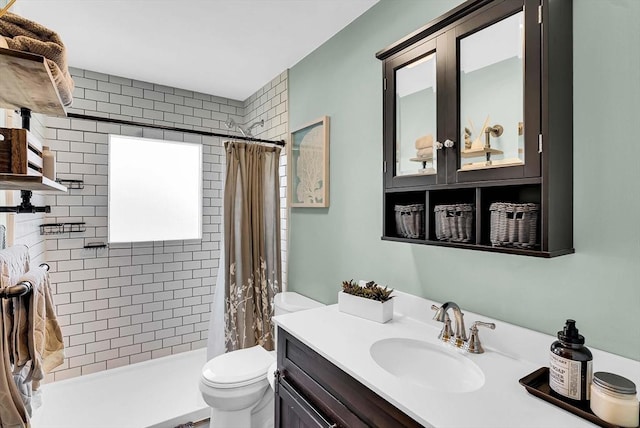 bathroom with vanity, toilet, and a tile shower