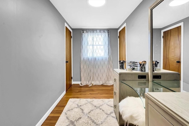 laundry area featuring baseboards and wood finished floors