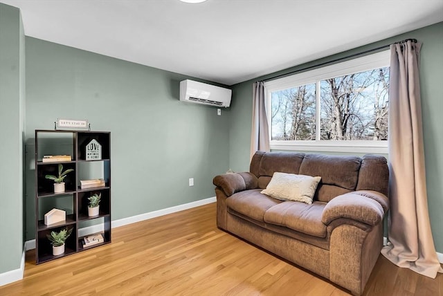 living room featuring a wall unit AC, wood finished floors, and baseboards