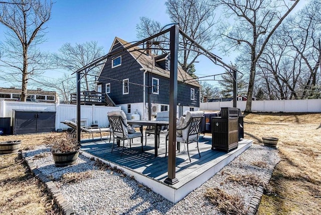 wooden terrace with a fenced backyard