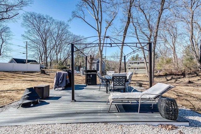 wooden deck featuring area for grilling, outdoor dining space, and fence