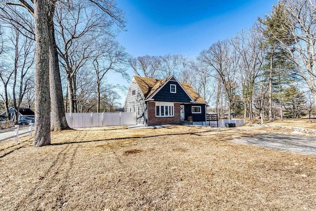 view of front of house featuring brick siding and fence