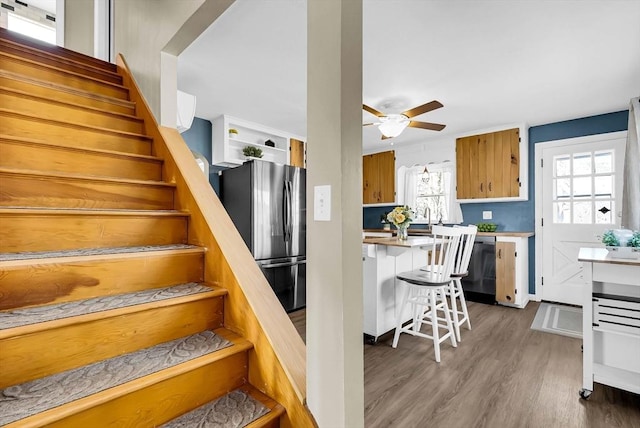 stairs with wood finished floors and ceiling fan