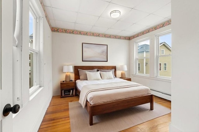 67-69 Nesmith St, Lawrence, MA 01841 - bedroom with a baseboard heating unit, light wood-type flooring, and a paneled ceiling