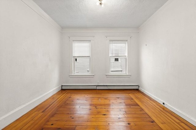 67-69 Nesmith St, Lawrence, MA 01841 - unfurnished room with a baseboard heating unit, a textured ceiling, and hardwood / wood-style floors
