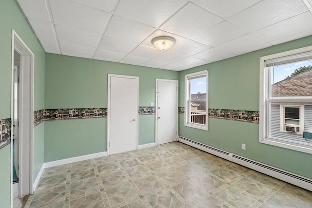67-69 Nesmith St, Lawrence, MA 01841 - empty room with a baseboard heating unit, a paneled ceiling, and plenty of natural light