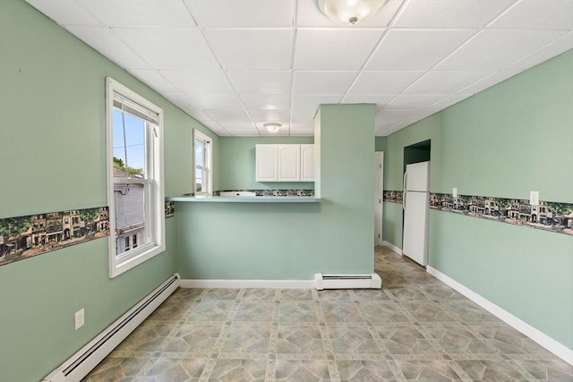 67-69 Nesmith St, Lawrence, MA 01841 - kitchen with baseboard heating, a paneled ceiling, freestanding refrigerator, and white cabinetry