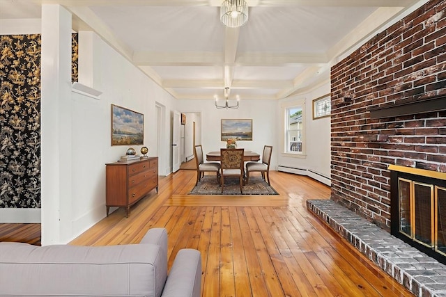 67-69 Nesmith St, Lawrence, MA 01841 - dining area with baseboard heating, a chandelier, light wood finished floors, beamed ceiling, and a fireplace
