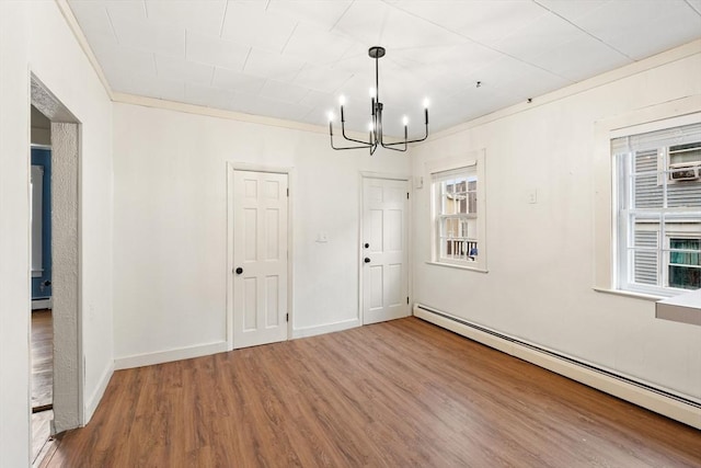67-69 Nesmith St, Lawrence, MA 01841 - spare room featuring baseboard heating, a chandelier, and wood finished floors