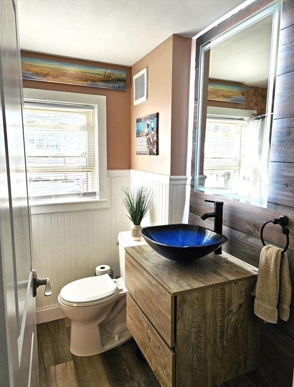 bathroom with vanity, toilet, and hardwood / wood-style floors