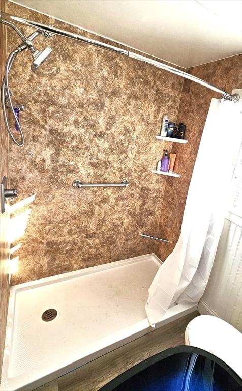 bathroom featuring curtained shower and toilet