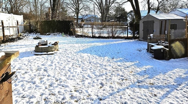 snowy yard featuring a shed