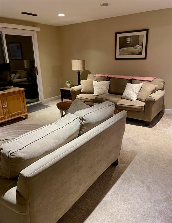 living room with recessed lighting, visible vents, light colored carpet, and baseboards