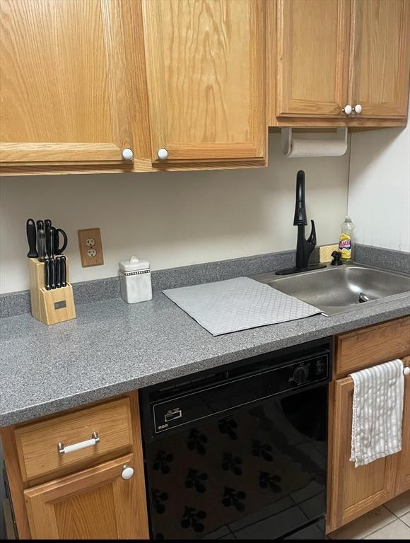 kitchen featuring light tile patterned floors, dishwasher, and a sink