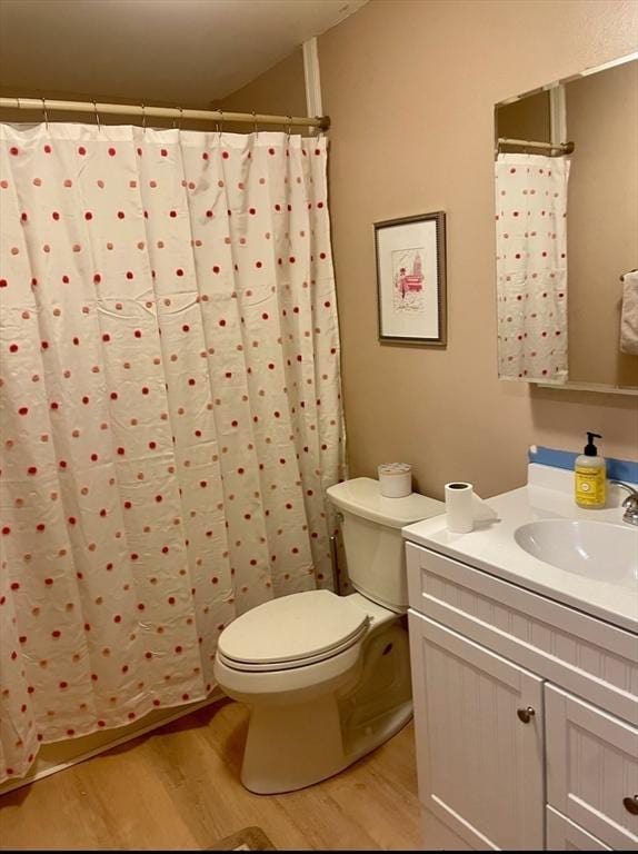 full bathroom with toilet, vanity, and wood finished floors