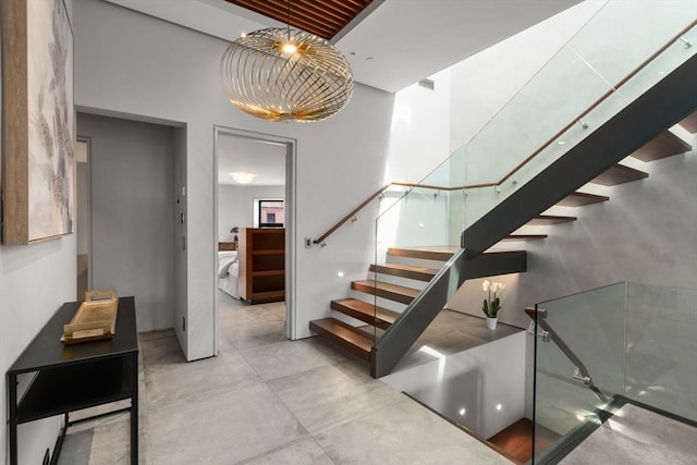 stairs with concrete floors and a towering ceiling