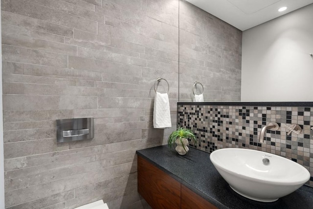 bathroom featuring tile walls, vanity, backsplash, and recessed lighting