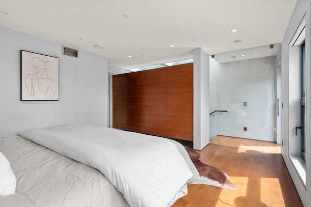 bedroom with light wood finished floors and recessed lighting