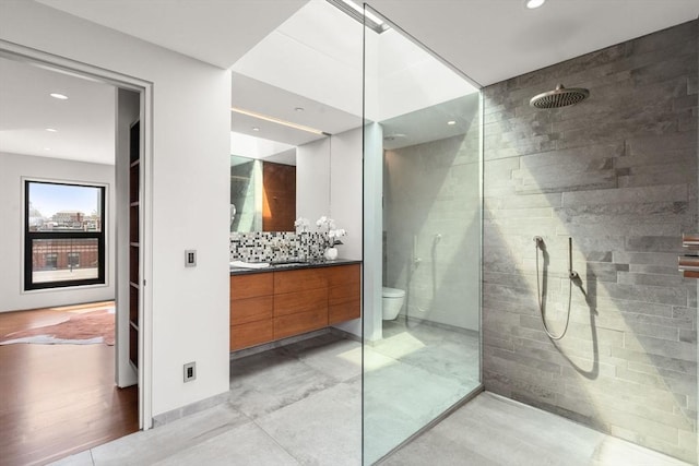full bathroom with recessed lighting, a walk in shower, vanity, toilet, and backsplash
