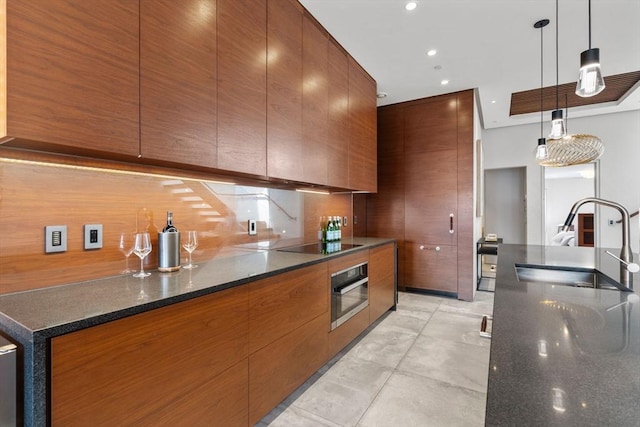 kitchen featuring stainless steel oven, modern cabinets, a sink, and recessed lighting