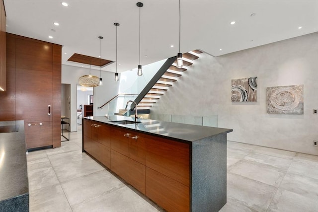kitchen featuring modern cabinets, a sink, dark countertops, and recessed lighting