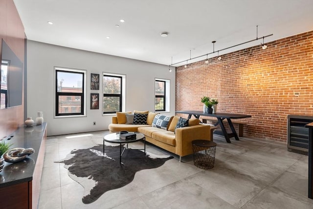living room featuring brick wall, plenty of natural light, and wine cooler