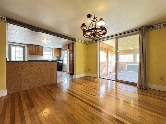 45 Gardner Rd, Hubbardston, MA 01452 - unfurnished living room with light wood-type flooring, a chandelier, and baseboards