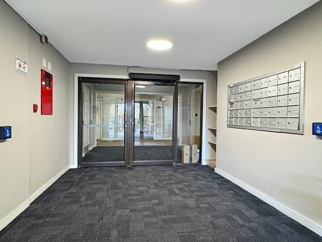 hallway featuring dark colored carpet and mail boxes