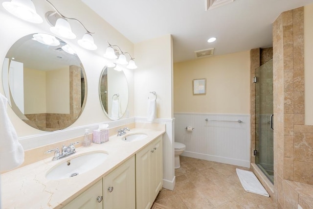 bathroom featuring tile patterned floors, vanity, toilet, and a shower with door