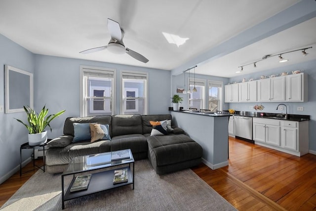 living area featuring ceiling fan, wood finished floors, and baseboards