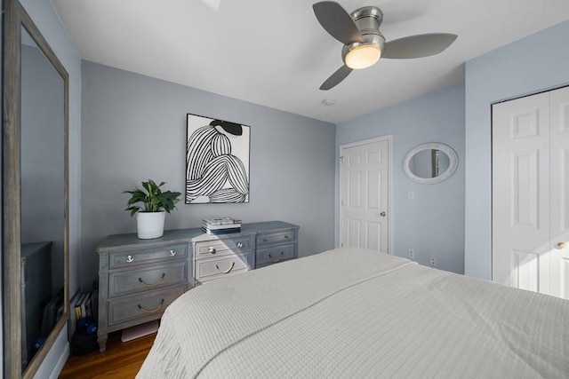 bedroom with ceiling fan, dark wood-type flooring, and a closet