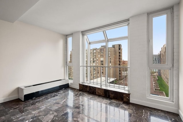 spare room featuring baseboards, marble tiled floors, and a view of city