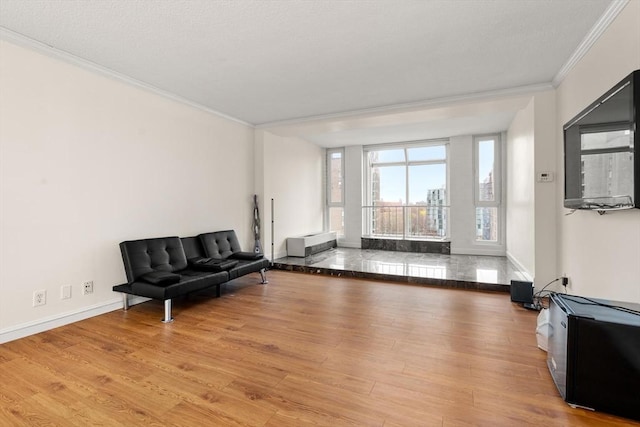 sitting room with ornamental molding, wood finished floors, and baseboards