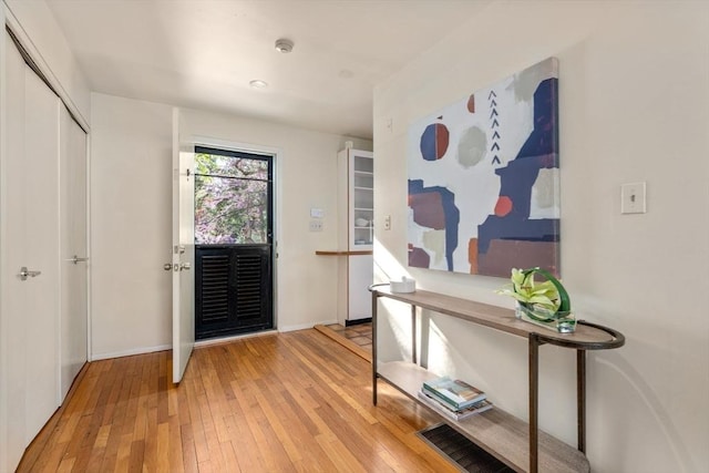 foyer entrance with baseboards and hardwood / wood-style floors