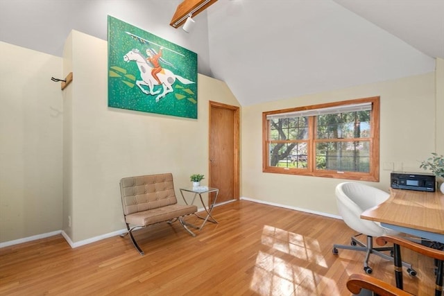 office with baseboards, vaulted ceiling, and light wood-style flooring