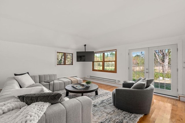living room featuring french doors, a baseboard heating unit, and light wood-style flooring