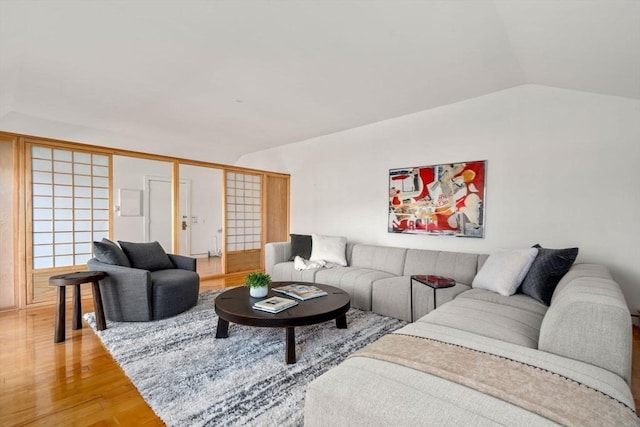 living area with light wood-style flooring and lofted ceiling