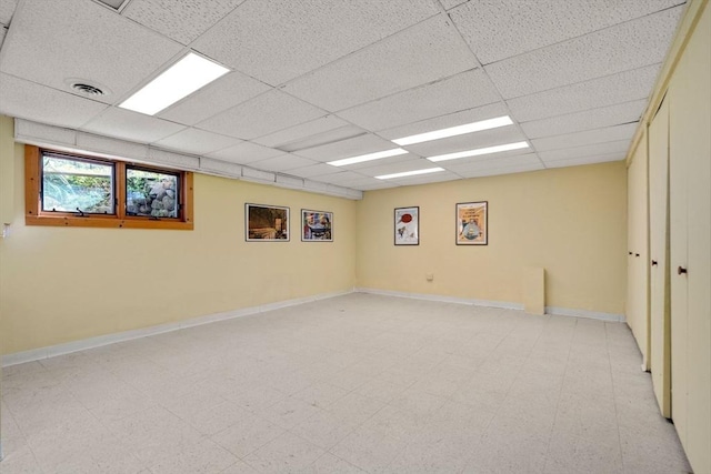 empty room featuring baseboards, visible vents, a paneled ceiling, and light floors