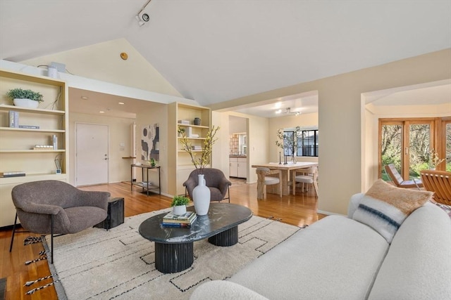 living room with wood finished floors and high vaulted ceiling
