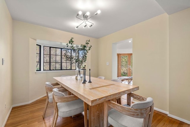 dining area with baseboards and light wood finished floors