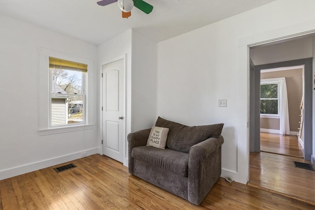 sitting room featuring baseboards, a ceiling fan, wood finished floors, and visible vents
