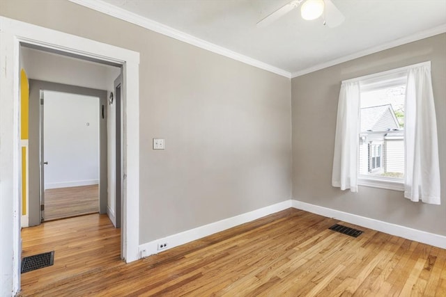 unfurnished room featuring visible vents, light wood-style flooring, crown molding, and baseboards