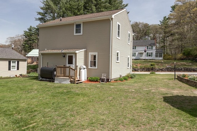 rear view of house featuring heating fuel and a yard