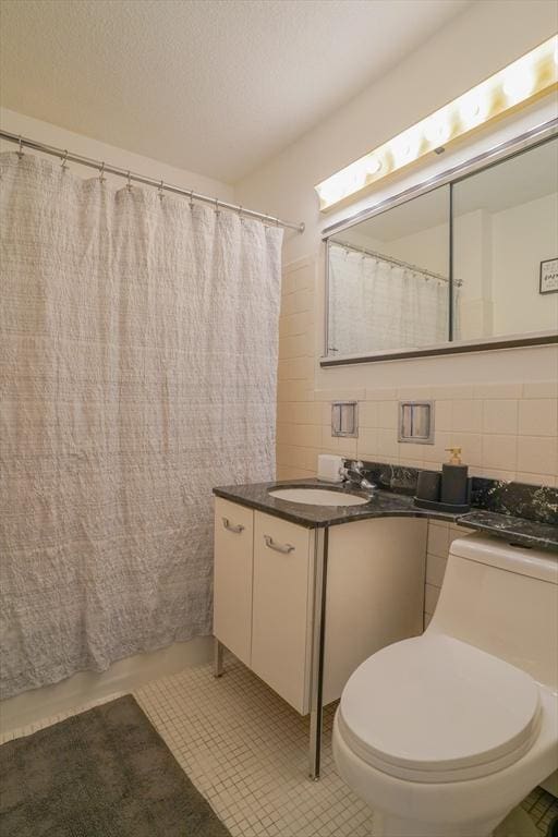 full bathroom with vanity, tile patterned flooring, toilet, tile walls, and tasteful backsplash