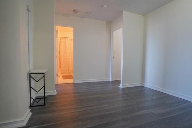 empty room featuring dark hardwood / wood-style flooring and a textured ceiling